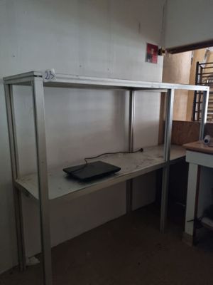 un bureau sur lequel se trouve un ordinateur portable, dans un coin de la pièce