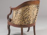 a chair with a leopard print upholstered back and wooden legs