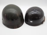 pair of wwii era german steel helmets on a white background