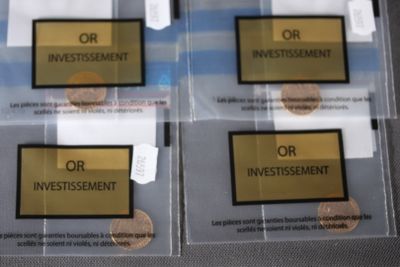 three clear bags with gold and black labels on them sitting on a table