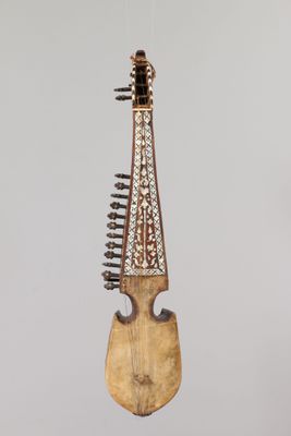 wooden musical instrument hanging from a string on a gray background