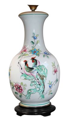 un vase blanc orné d'un oiseau et de fleurs