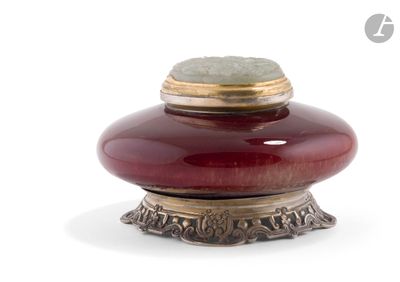 un vase rouge contenant une pierre verte