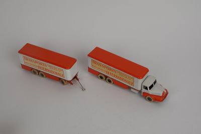 two toy trucks sitting next to each other on a white surface