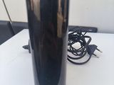 a black vase sitting on a white table next to a charger