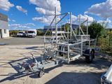 a trailer with a ladder attached to it in a parking lot