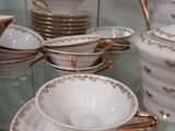 de nombreuses pièces de vaisselle blanche et dorée exposées dans une vitrine