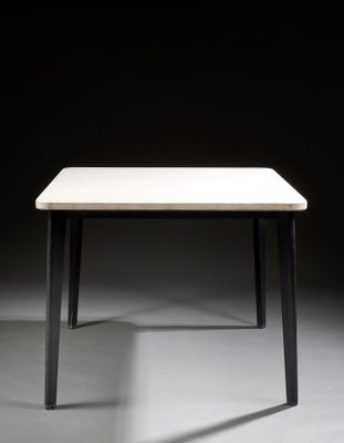 a white table with black legs and a white table top