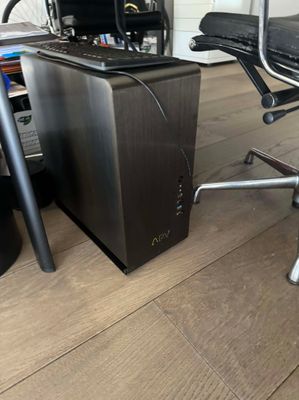 un ordinateur de bureau posé sur un bureau, à côté d'une chaise