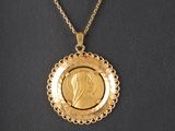 un pendentif en forme de pièce d'or représentant le visage d'une femme