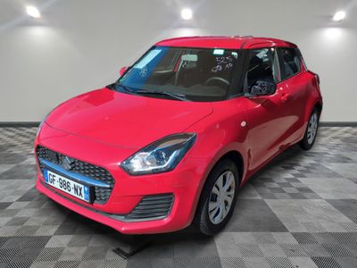 a red car is parked on a checkered floor in a garage