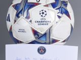 a soccer ball with a signed card on top of it