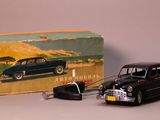 a black toy car and a black toy car in front of a box