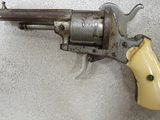an old revolver with a yellow handle on a white surface