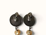 two pairs of black and gold earrings on a white background