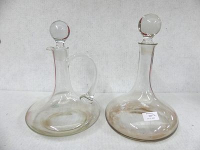 two glass decanters sitting on a white surface