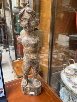 a statue of a man on a table in front of a glass case
