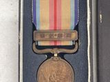 an old military medal in a box with a ribbon around it