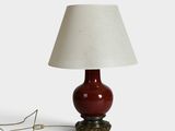une image représentant une lampe rouge surmontée d'un abat-jour blanc