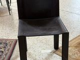 une chaise noire placée au milieu d'un salon