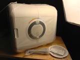 a white radio sitting on top of a table next to a light