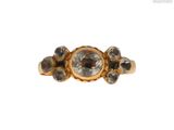 a close up of a gold ring with a white diamond