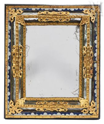 a close up of a mirror on a white surface with a gold frame
