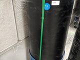 a black trash can sitting on a blue stand