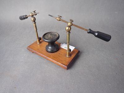 une petite horloge posée sur un socle en bois, munie d'une poignée noire