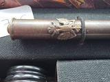 a metal pipe with a lion head on it next to a stack of books