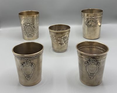 quatre coupes en argent ornées de motifs, posées sur une table