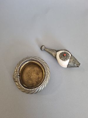 assiette en argent représentant un oiseau et un bol de soupe posés sur une table