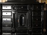 a black cabinet with drawers and a vase on top of it