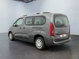 the grey van is parked in a large room with a black floor