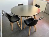 une table entourée de quatre chaises dans une pièce