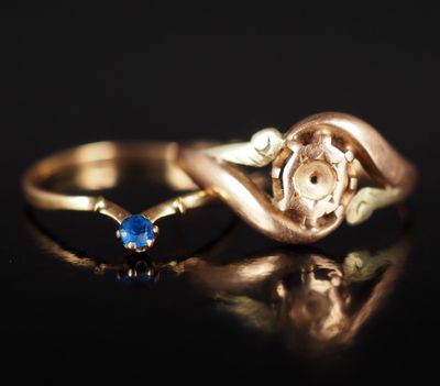 une image représentant une bague en or sertie d'une pierre bleue sur un fond noir