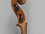 an old violin with a wooden bow on a gray background
