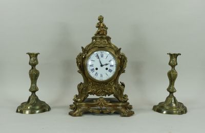 trois bougies et une horloge posées sur une table