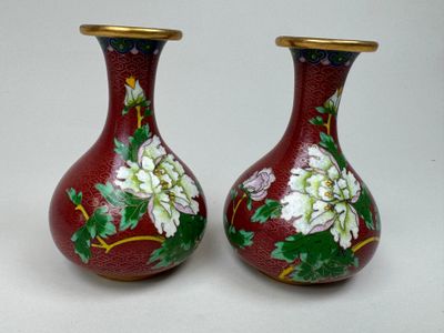 deux vases avec des fleurs peintes dessus, posés sur une table