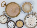 many different types of pocket watches on a white surface