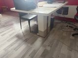 a desk with a computer and a chair in the room