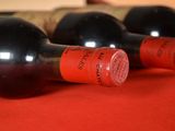 several bottles of wine are lined up on a red table