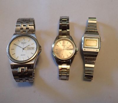 trois montres sont assises l'une à côté de l'autre sur une table