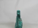 a green statue of a woman with a dog on her lap