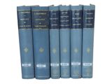 six blue books are lined up in a row on a white surface