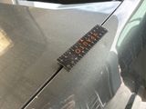 a ruler on the hood of a car that is parked in a parking lot