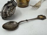 several spoons and spoon rest on a table next to a jar of flowers
