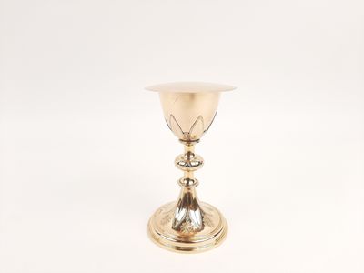 a silver cup on a white surface with a white background
