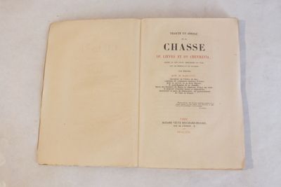 un livre ouvert posé sur une table blanche recouverte de feuilles de papier