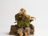 a figurine of a man sitting on a pile of books